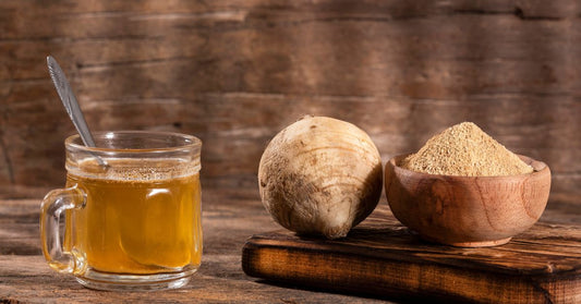 Pieces of raw maca root alongside a steaming cup of maca root tea, showcasing the natural ingredients and the soothing brew that promotes wellness
