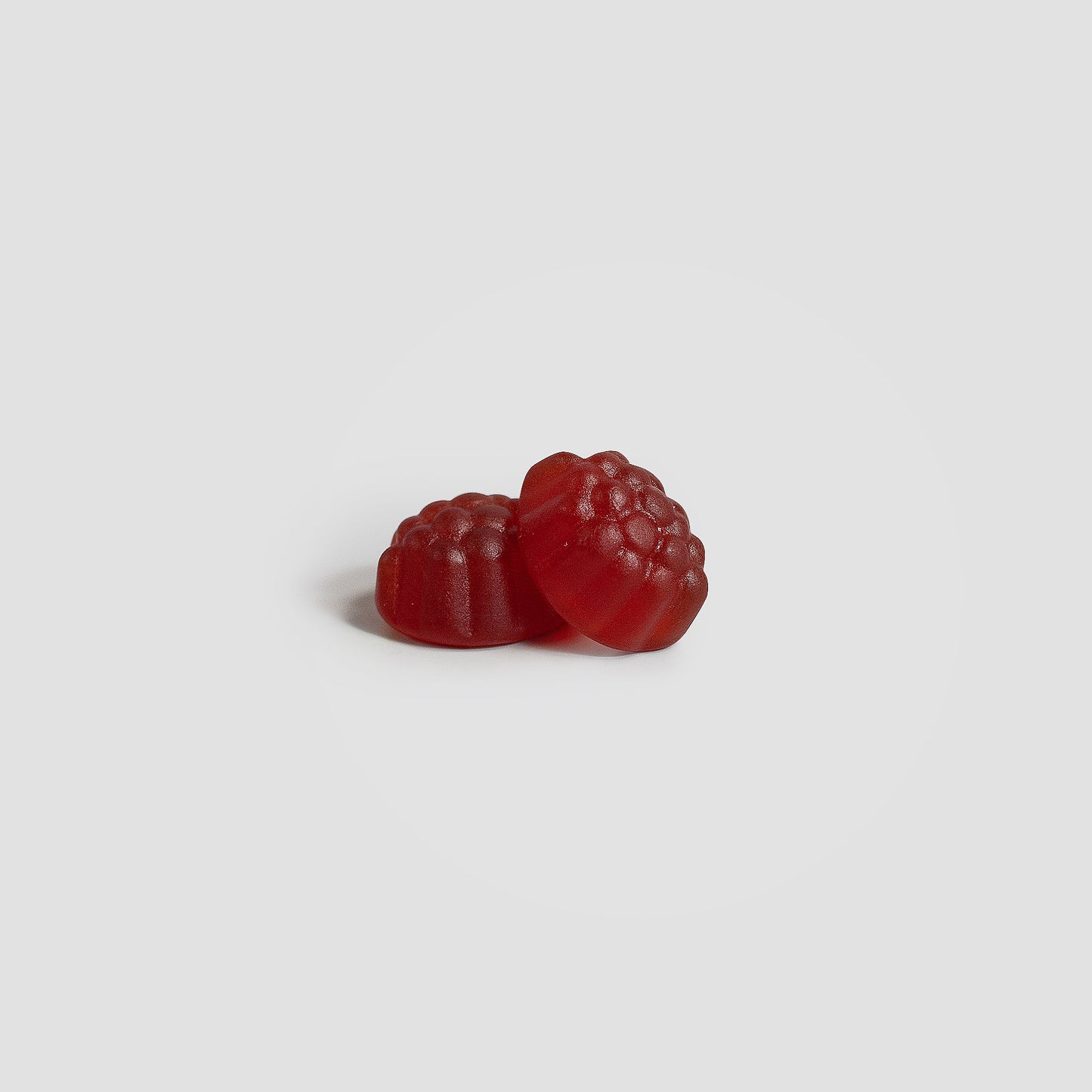 Two red gummy candies on a white background