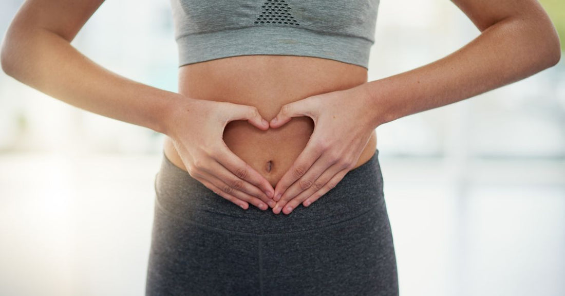 Woman forming a heart shape with her hands over her belly, symbolizing the importance of probiotics for gut health